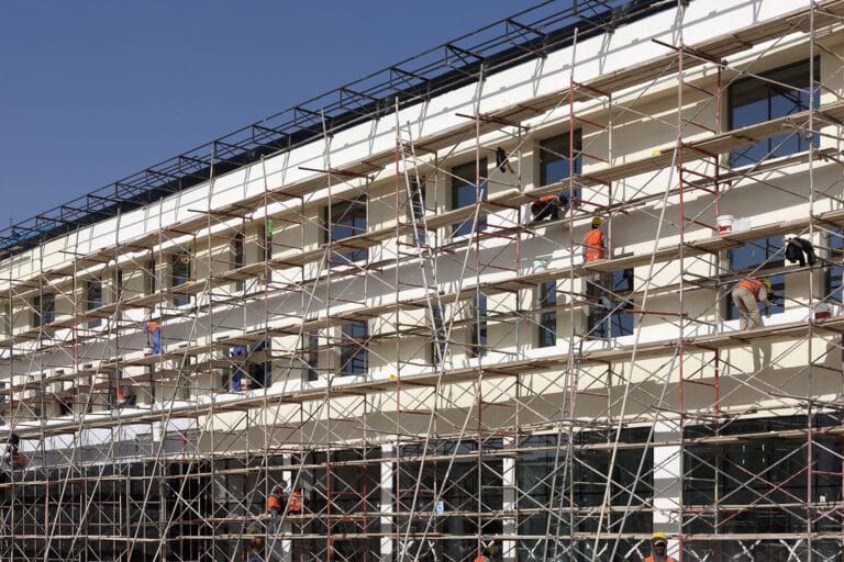 Building under construction with exposed structure and scaffolding, illustrating how early planning decisions shape what is actually deliverable on site.